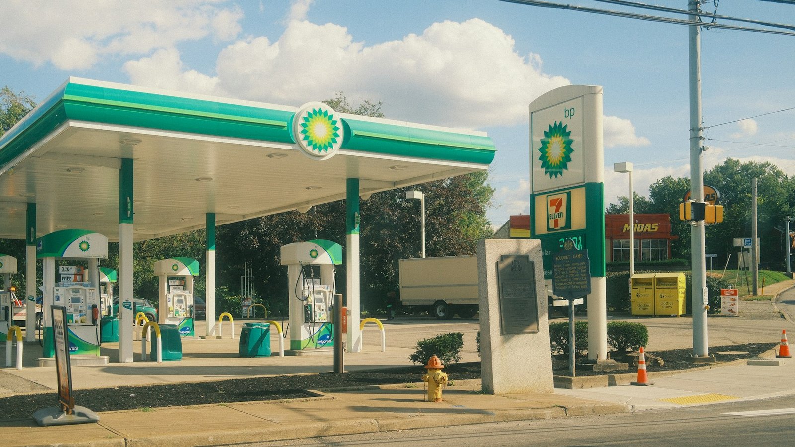 Estación de servicio con surtidores de combustible bajo un techo blanco