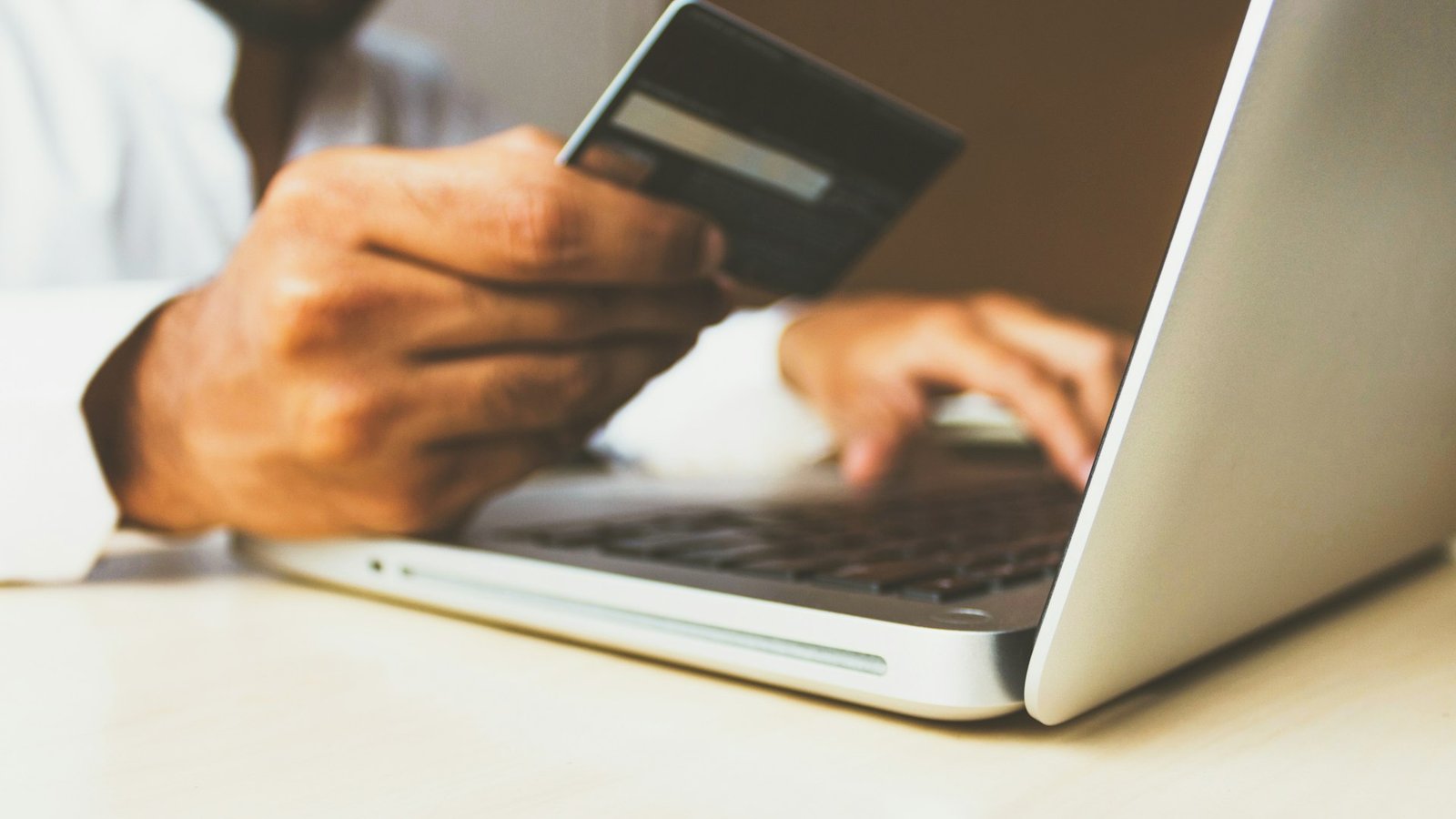 Compra en línea con tarjeta de crédito y laptop, representando una tienda virtual WooCommerce